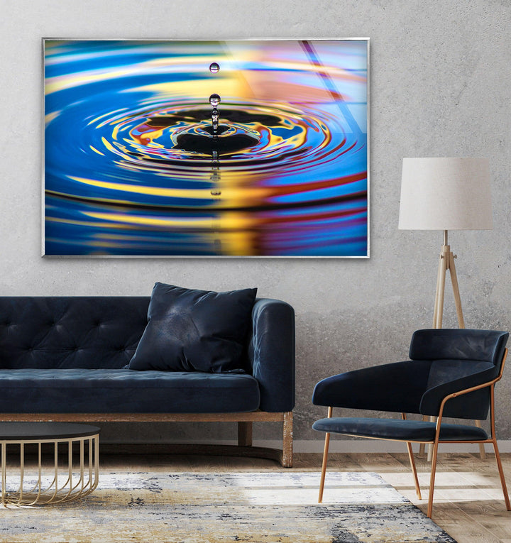 High-definition glass artwork of a droplet creating waves in a colorful reflective surface.
