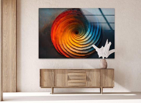 Abstract glass printing featuring a swirling orange and blue circle with ample negative space and a textured wall backdrop.