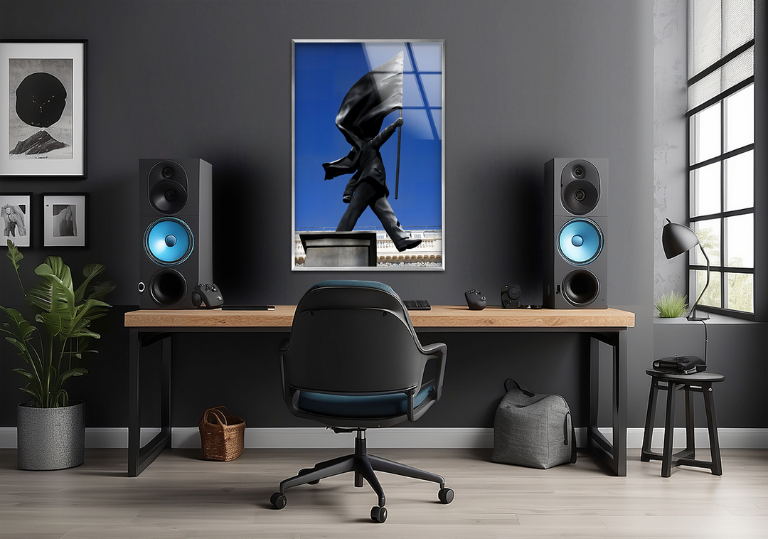Dramatic light and shadow define a Banksy flag statue as modern glass wall art decor, centrally illuminating a minimalist workspace.