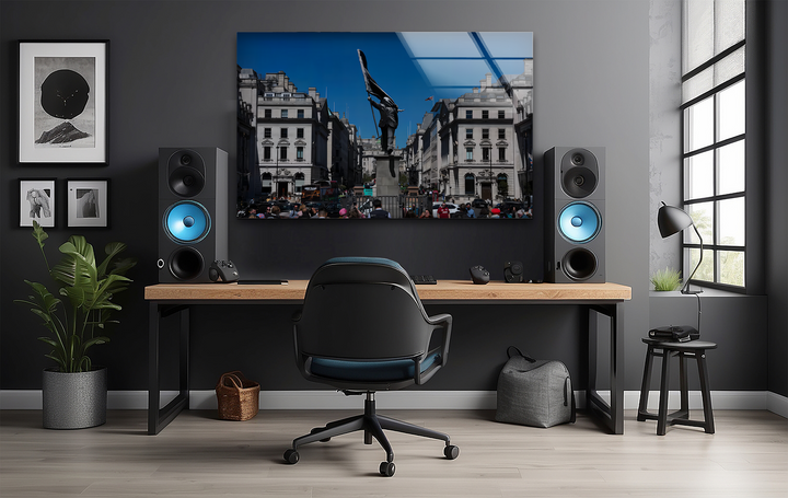 Expansive dark wall negative space frames a vibrant London Banksy glass art painting, complemented by minimalist decor in a contemporary office.