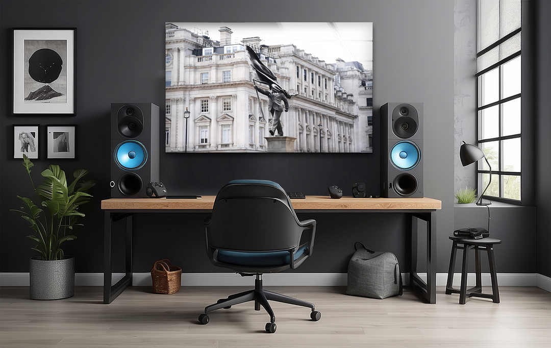 The deeply shadowed wall frames a striking London Banksy statue glass wall art prints, surrounded by dark minimalist furnishings.
