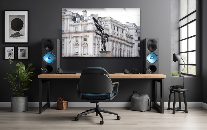 The deeply shadowed wall frames a striking London Banksy statue glass wall art prints, surrounded by dark minimalist furnishings.
