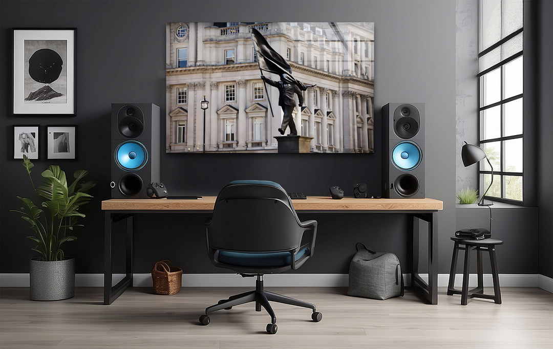 Surface textures reveal the glossy, reflective finish of the best glass art featuring a Banksy statue, juxtaposed with matte speakers and smooth wood.