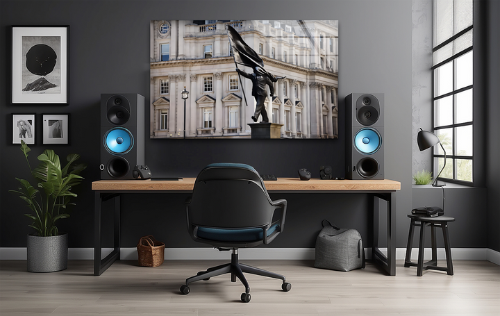Surface textures reveal the glossy, reflective finish of the best glass art featuring a Banksy statue, juxtaposed with matte speakers and smooth wood.