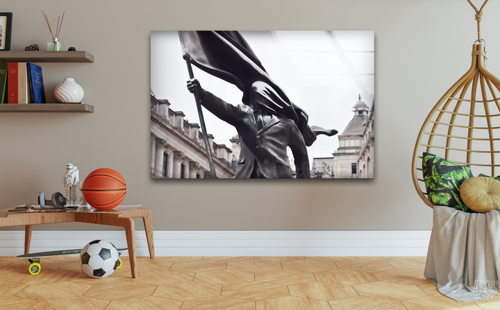A dramatic black and white statue of a figure raising a flowing flag, captured as best glass art, symbolizing strength and modern street art.