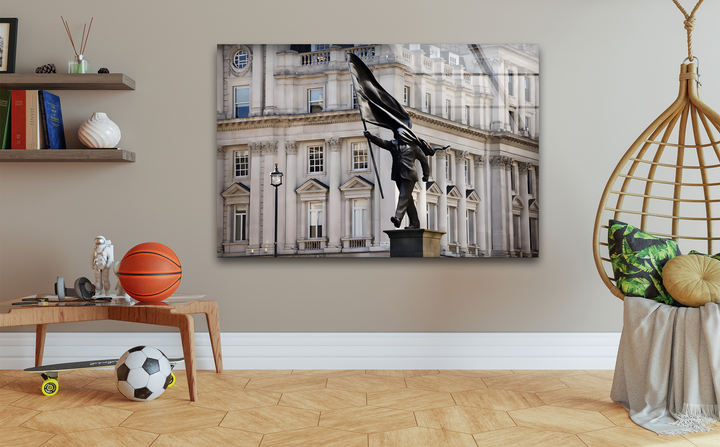 Expansive empty wall space frames the striking Banksy Stride of Freedom Statue art from glass, creating a serene modern interior.