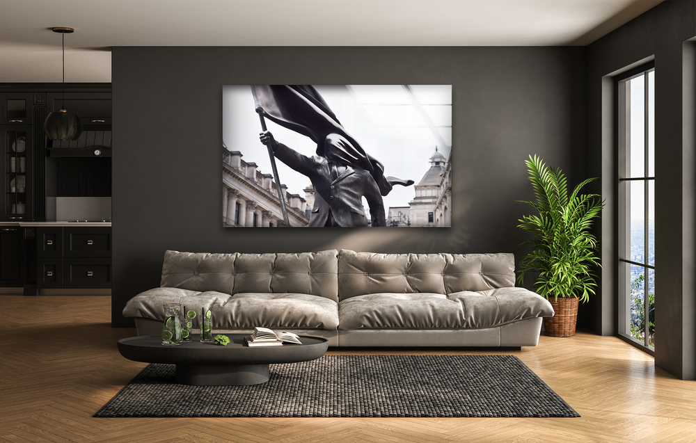 Depth and layers are created by the striking Banksy Flag Bearer glass wall art decor over a sofa, extending to the visible kitchen and distant window view.