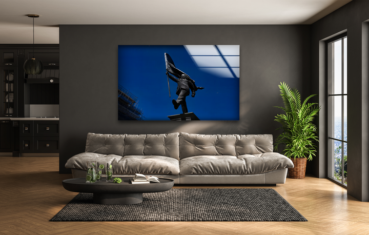 The focal point is a Banksy Flag Bearer Sky Glass Wall Art showing a dark statue against a deep blue sky, an impactful modern home decor element.