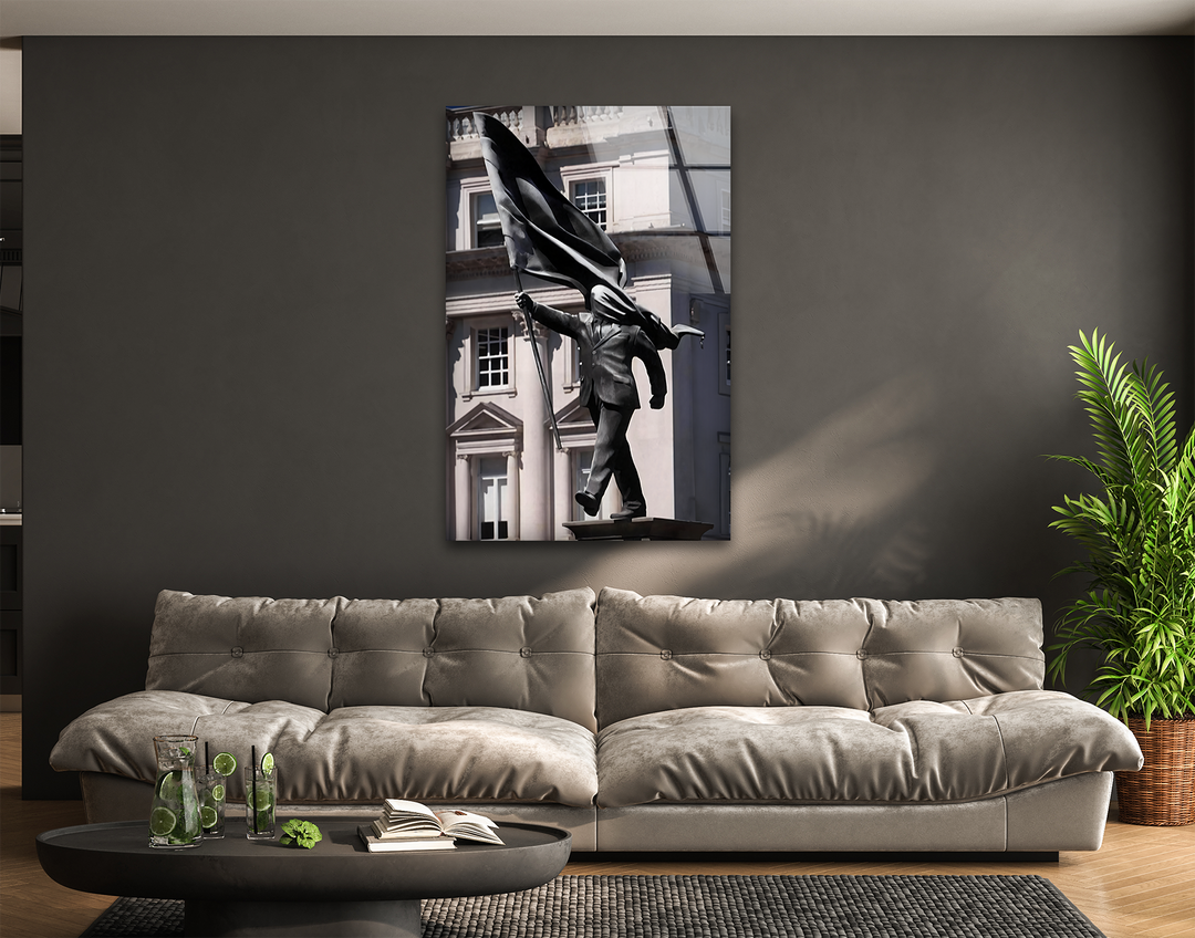 Featuring a neutral color temperature, this glass wall art decor showcases a compelling Banksy sculpture in Central London.