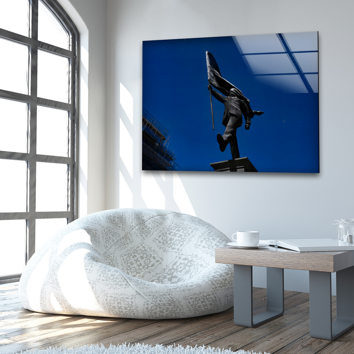 A patterned beanbag and a minimalist coffee table with a mug rest in the foreground, complementing the Banksy flag bearer tempered glass wall art.