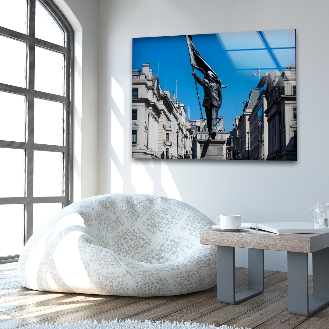 Distinct layers of depth are created by the reflective glass home decoration, revealing a striking Banksy statue under a vibrant blue sky.
