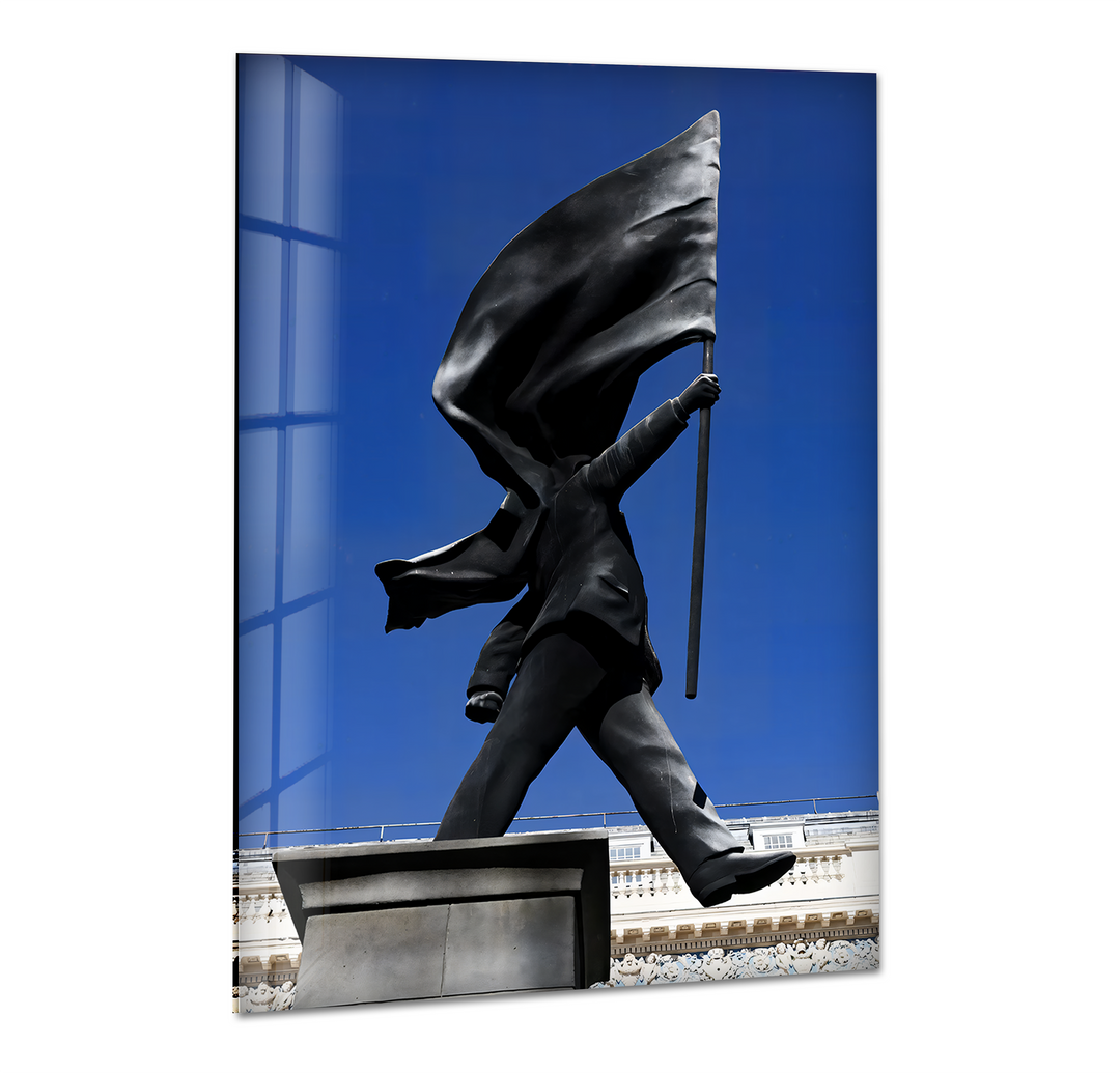 The soft, flowing folds of the black flag held by the iconic Banksy statue stand out against the vibrant blue sky in this glass wall artwork.