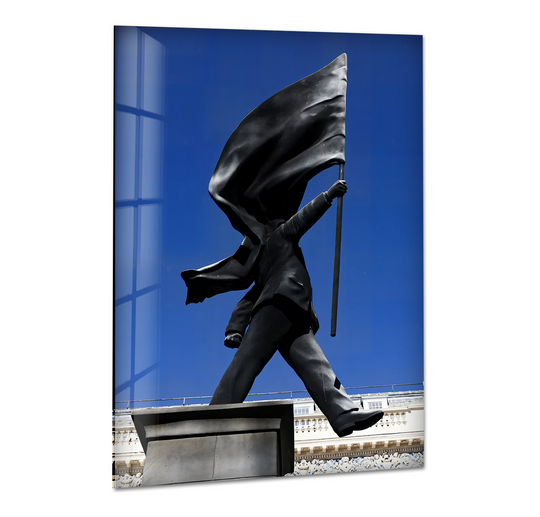 The soft, flowing folds of the black flag held by the iconic Banksy statue stand out against the vibrant blue sky in this glass wall artwork.