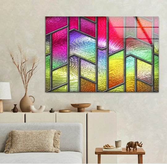 This pink and yellow abstract art from glass features a dark, thin border framing the multi-paneled design.