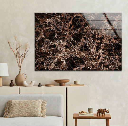 A detailed close-up of unique modern wall decor featuring a striking copper and black marble abstract design on glass.