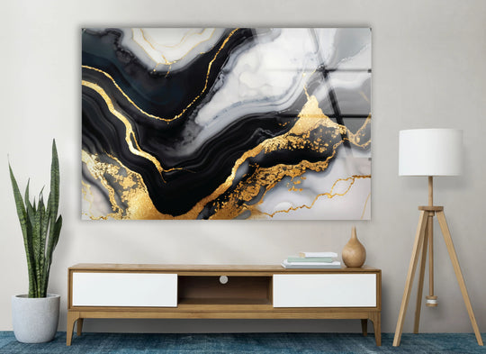 The abstract glass wall art decor displays a luxurious blend of light and shadow in black, white, and gold marbled patterns.