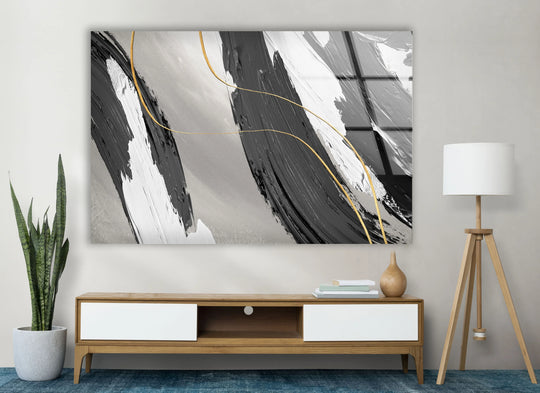 A contemporary entertainment unit with white drawers sits below a framed monochrome gold abstract glass art painting.