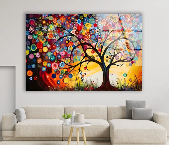 Swirling circular forms of a vibrant glass wall artwork seem to dance around a blooming tree.