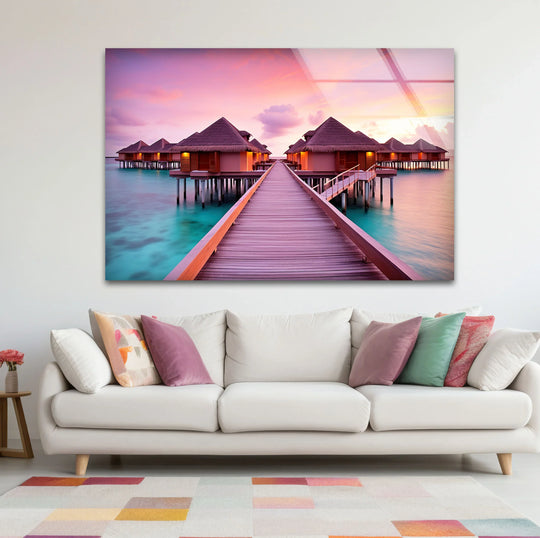 Gleaming decorative wall art vividly captures the Maldives bungalows and pathway at sunset, creating a striking focal point above the white sofa.