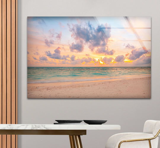 Clean edges and borders define this unique modern wall decor, a pastel beach sunset glass print with a tranquil ocean shoreline.
