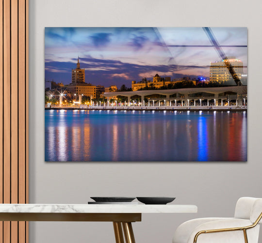 City Prints with a dusk skyline and waterfront view glossy glass wall art brings Malaga cityscape urban decor and modern coastal interiors