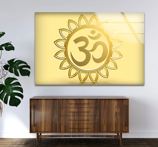 Golden Om symbol spiritual Hindu decor, a striking piece of glass art, radiates from a sleek golden canvas print on the wall above a mid-century cabinet.