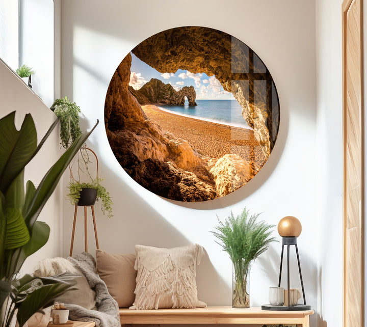 Golden-hour beach landscape, framed by rugged cave walls.
