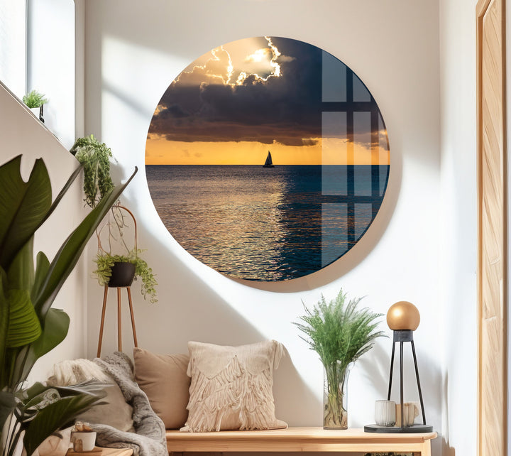 Serene ocean sunset with vibrant golden skies and a lone sailboat in the distance.
