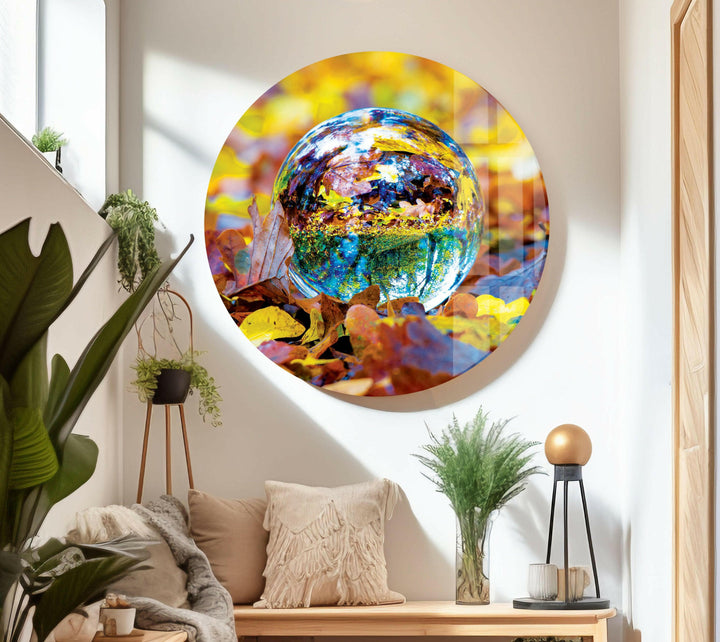 Glass wall art capturing the magic of a glass ball mirroring golden leaves in a serene setting.
