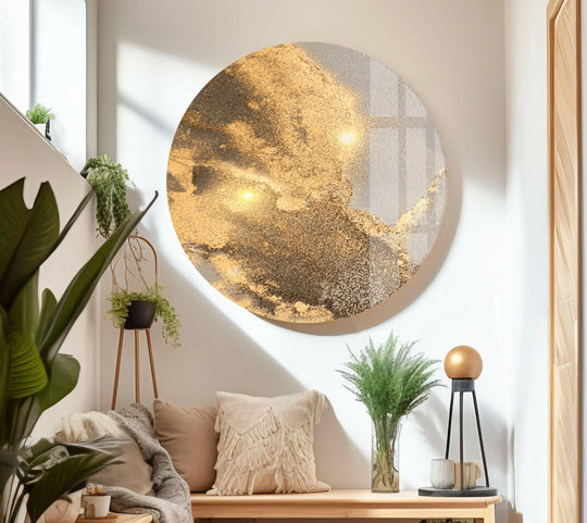 A circular glass wall artwork with shiny gold alcohol ink abstract patterns.