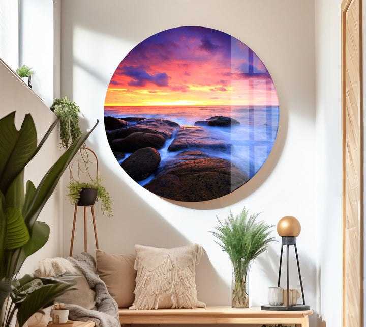 Nature-inspired glass wall art featuring a peaceful sunset over the sea and coastal rocks.
