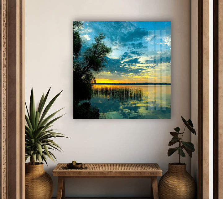 High-definition glass wall art capturing a scenic sunset over calm waters.
