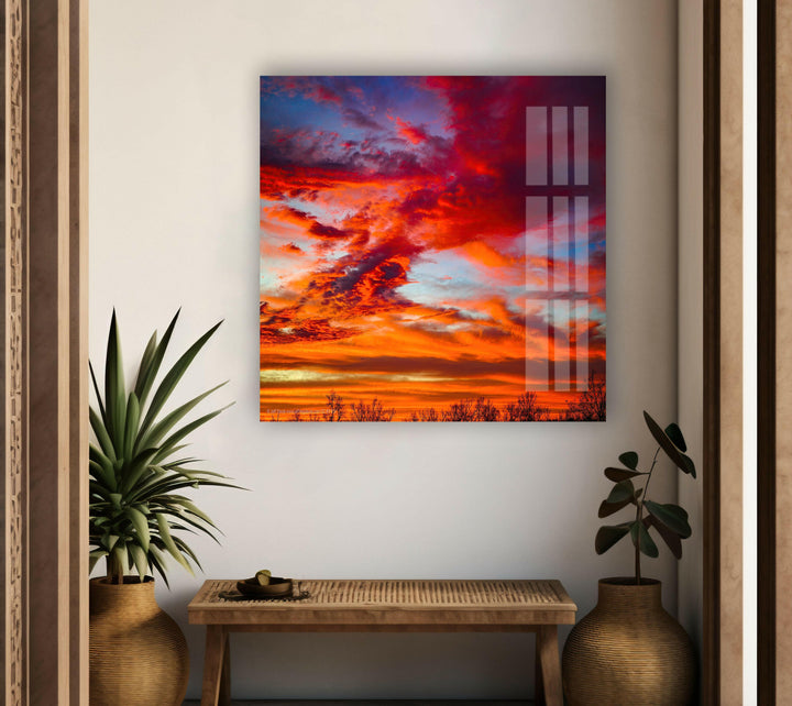 Fiery sunset clouds in brilliant shades of red, orange, and blue, illuminating the sky.
