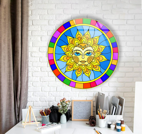Behind the colorful sun face boho decor, a white brick wall serves as a clean backdrop to the vibrant round glass art painting.