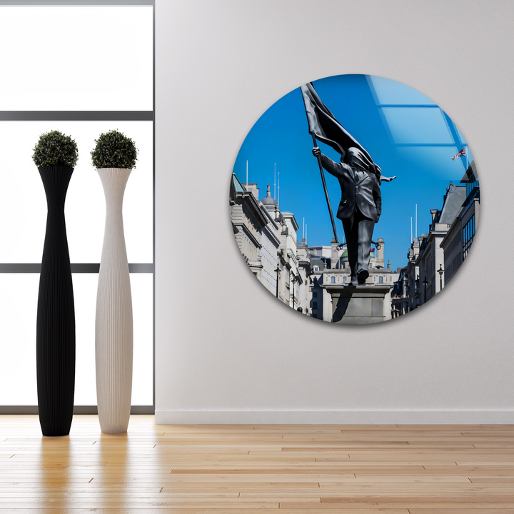 The cool color temperature of this Banksy wall art glass printing highlights the vibrant azure sky and crisp details of the Freedom March statue.