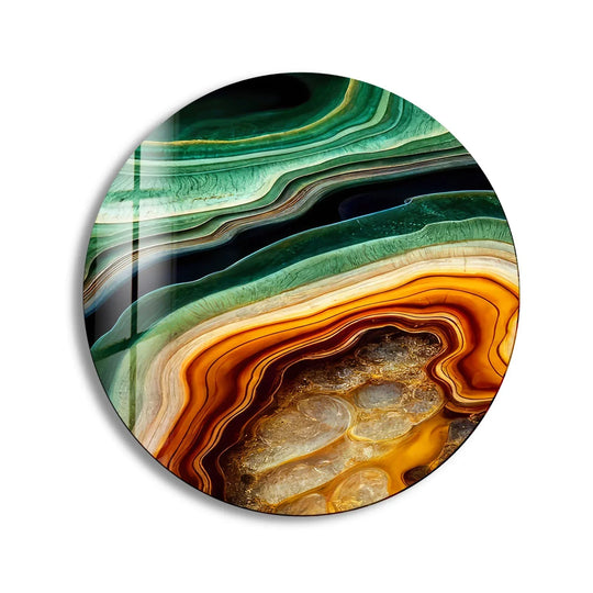 Layered bands of green, gold, and brown form concentric arcs, creating a dynamic geometric print wall art effect in this round glass piece.