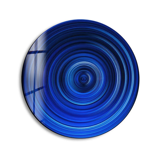 Smooth, reflective edge of the round glass art accentuates the concentric blue lines, creating a captivating border for this modern decor.
