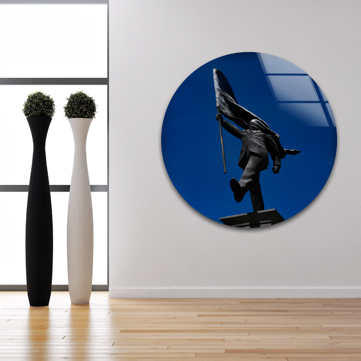 The layering effect of the circular glass art, depicting a dynamic Banksy flag bearer against a deep blue sky, makes for captivating home decor.