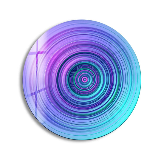 The stillness of the purple and blue abstract spiral in round glass art captivates with its hypnotic flow, a mesmerizing design suspended in time.