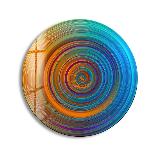 Gradual transitions of orange and blue hues create a vibrant spiral in this mesmerizing abstract round glass wall artwork, showcasing a dynamic shift in color.