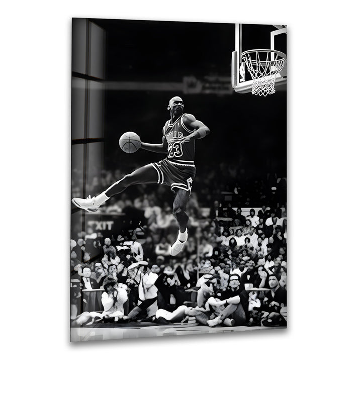 A legendary black and white glass wall art capturing Michael Jordan soaring for a powerful dunk.

