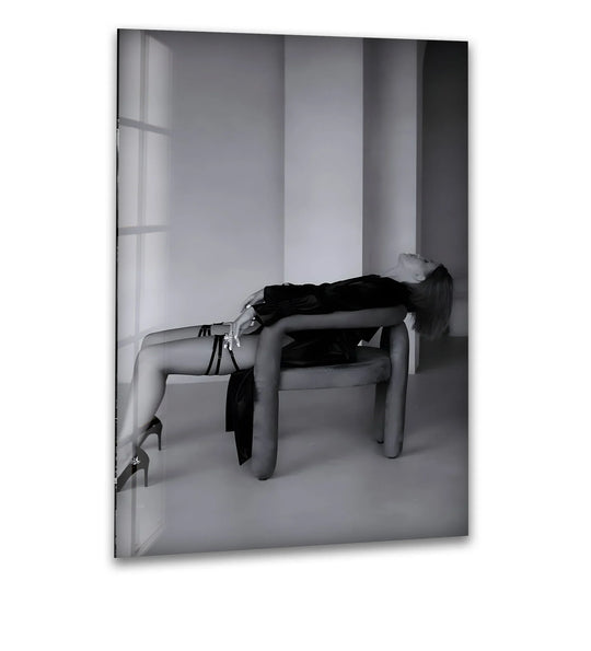 Elegant woman in a black satin robe reclines provocatively on a chair in this striking black and white glass art piece.
