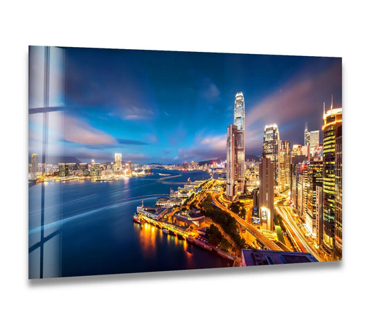 Illuminated buildings cast long shadows across the waterfront in this Hong Kong skyline print wall art, capturing the interplay of light and darkness in the night cityscape.