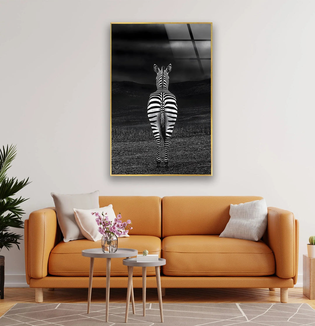 Dramatic monochrome glass wall art featuring a solitary zebra standing in an open, shadowy field.