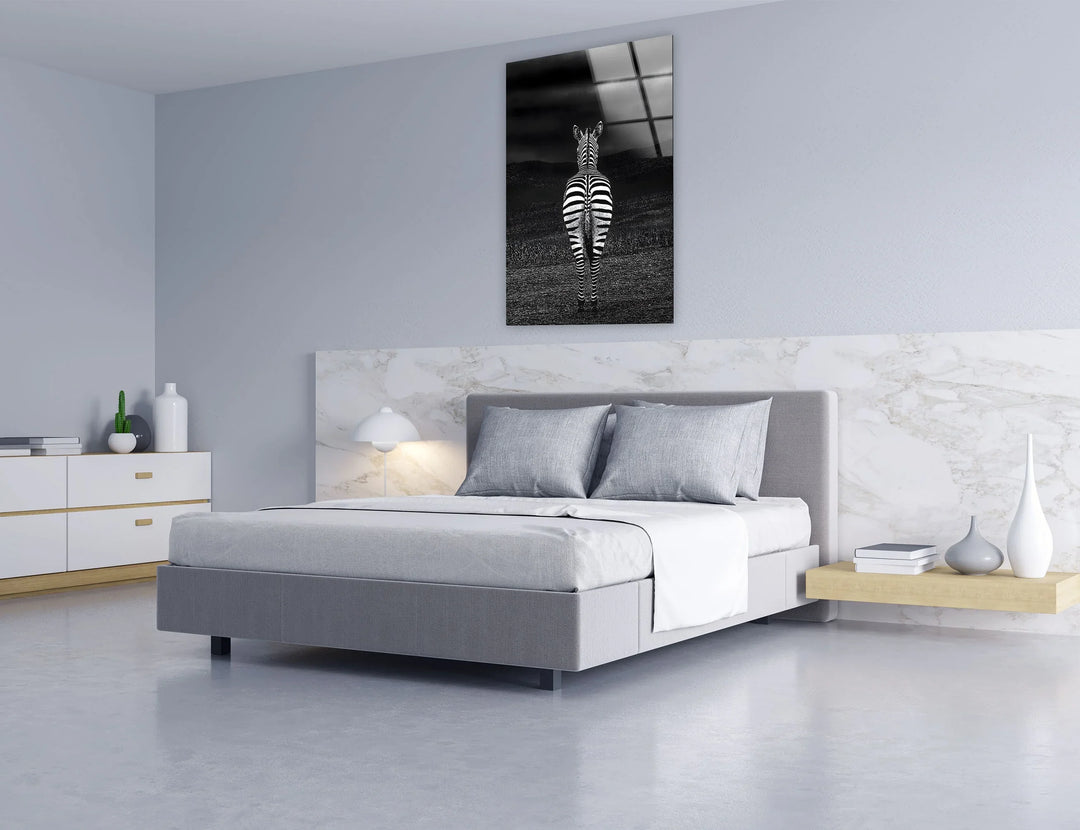 Artistic monochrome zebra composition on glass emphasizing contrast between stripes and dark terrain.