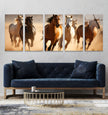 a living room with a couch and three horses on the wall