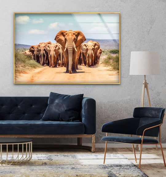 Elephants in the wild animal canvas wall art shows a herd walking along a dirt road and is safari decor in brown and blue tones