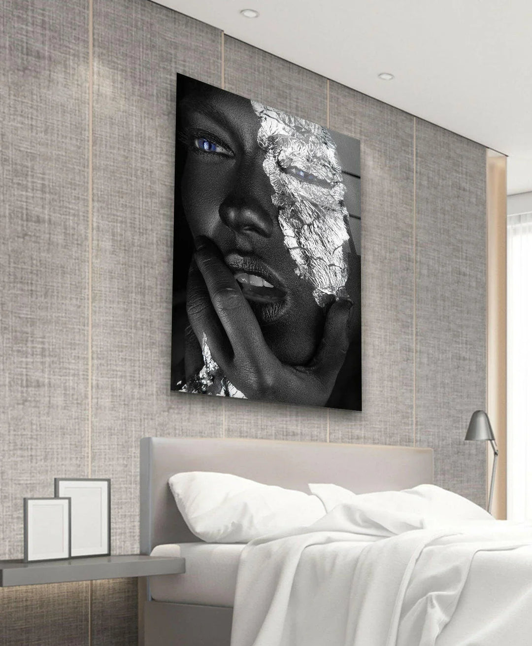 Artistic monochrome portrait with silver textured details and vibrant blue eyes on glass wall art.