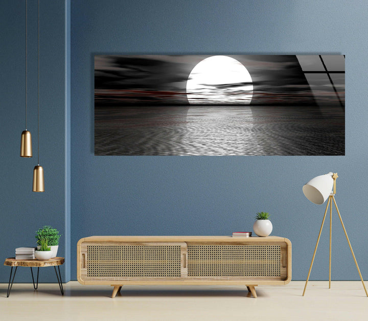 Black and white wall art showing an intense moonrise casting light over dark, calm waters.