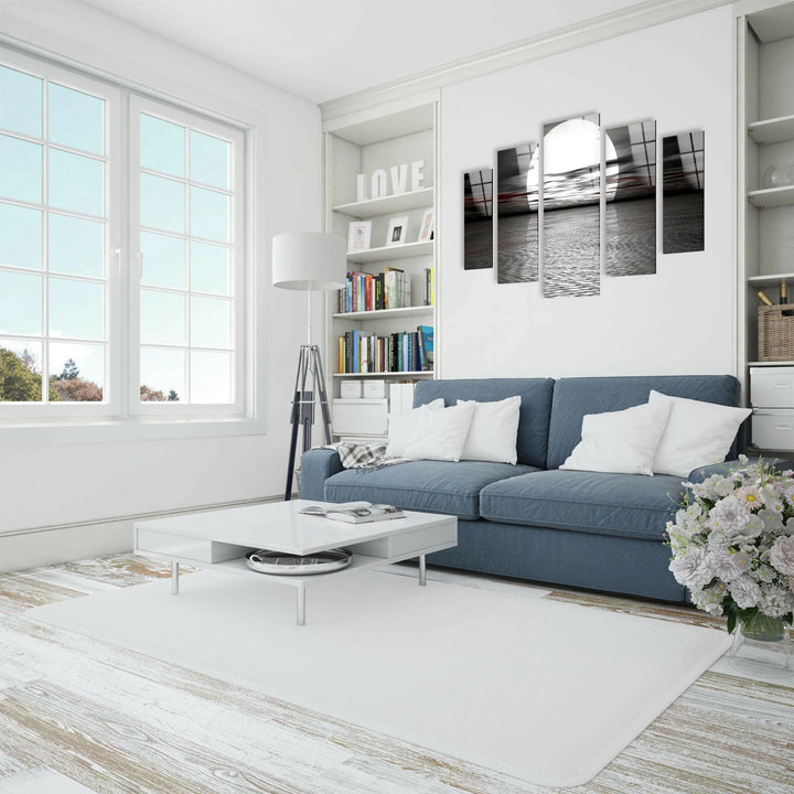 Minimalist black and white ocean artwork featuring a bold full moon and reflective waves.